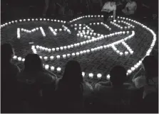  ?? Associated Press ?? n Relatives of Chinese passengers onboard Malaysia Airlines Flight 370 hold a candleligh­t vigil for their loved ones April 8, 2014, in Beijing.