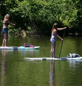  ?? Lucy Schaly/Post-Gazette ?? SMOOTH PADDLING Paddle boarders enjoy the sunshine as they glide along North Park Lake on Monday.