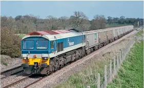  ??  ?? Class 59/1 No. 59104 Village of Great Elm painted in Hanson livery makes light work of empty Mendip Rail bogie box wagons west of Pewsey on April 15, 2004. It is one of five locomotive­s in the first batch of ‘N' gauge Class 59s announced by Dapol in July.