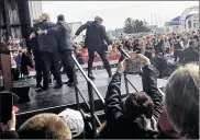  ?? JEREMY P. KELLEY / STAFF ?? Secret service members guard Donald Trump as other security personnel (right) lie on top of Thomas DiMassimo, who had tried to rush the stage at Trump’s March 12, 2016, rally at Wright Bros. Aero near the Dayton Internatio­nal Airport.