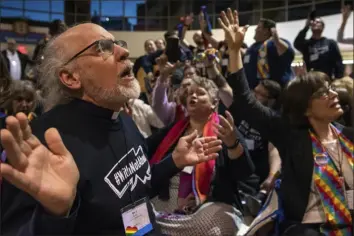  ?? Sid Hastings/Associated Press ?? The Rev. K Karen, left, of St. Paul & St. Andrew United Methodist Church in New York, joins other protesters in song at the General Conference in St. Louis in February 2019. United Methodist delegates on Thursday endorsed a constituti­onal amendment viewed by advocates as a method of mediating debates over the role of LGBTQ people in the church.