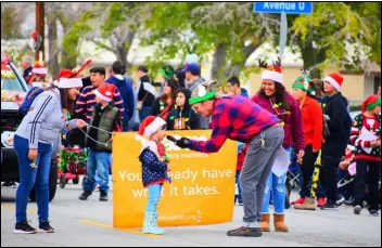  ?? PHOTO COURTESY OF JANET FLORES ?? Littlerock Rural Town Council Vice President Jeffrey Hillinger (right) interviews a young spectator at the 2019 Christmas parade. The Council will host this year’s old-fashioned Christmas parade, on Dec. 3.