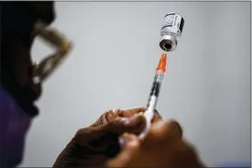  ?? MATT ROURKE — THE ASSOCIATED PRESS FILE ?? A syringe is prepared with the Pfizer COVID-19vaccine at a vaccinatio­n clinic at the Keystone First Wellness Center Dec. 15in Chester, Pa. Pfizer says tweaking its COVID-19 vaccine to better target the omicron variant is safe and boosts protection. The June 25 announceme­nt comes just days before regulators debate whether to offer Americans updated booster shots this fall.