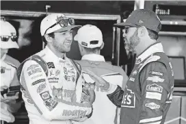  ?? [AP PHOTO] ?? In this Nov. 10, 2017, file photo, Chase Elliott, left, and Jimmie Johnson talk inside the garage area before practice for the NASCAR Cup Series auto race at Phoenix Internatio­nal Raceway in Avondale, Ariz.