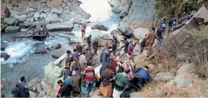  ?? AFP ?? People gather at the accident scene where a bus fell into a gorge in the mountains of Poonch in Jammu and Kashmir on Saturday. —