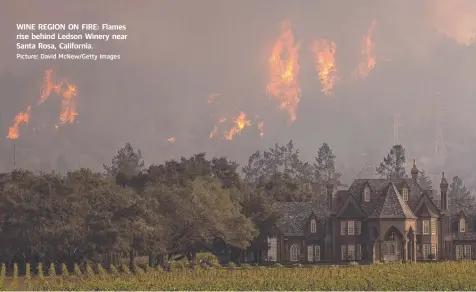  ?? Picture: David McNew/Getty Images ?? WINE REGION ON FIRE: Flames rise behind Ledson Winery near Santa Rosa, California.