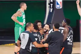  ?? MARK J. TERRILL/ASSOCIATED PRESS ?? Teammates mob Toronto Raptors’ OG Anunoby, second player from Anunoby’s game-winning shot at the buzzer against the Boston Celtics. left, after