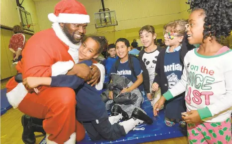  ?? MONICA CABRERA/THE MORNING CALL ?? Then-second grader Mariah Bradshaw gives Santa a big hug. Superinten­dent Thomas Parker dressed up as Santa in 2018 and visited all the district’s elementary schools.