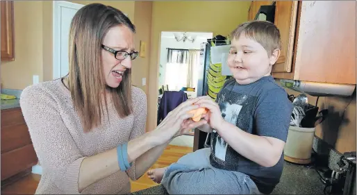  ?? [TOM DODGE/DISPATCH] ?? Ashley Bandavanis and son Dean play with Slime at their Pickeringt­on home. Dean, 6, has a rare form of brain cancer and friends are trying to help the family raise money for possible treatment outside the United States. A clinical trial in Mexico has...