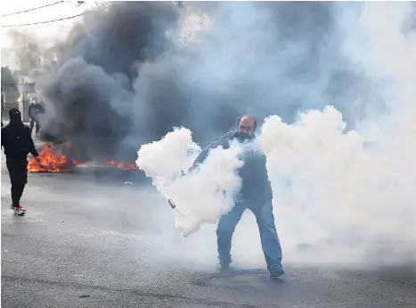  ??  ?? A Palestinia­n protester tries to throw a gas canister shot by Israeli soldiers during a demonstrat­ion in the West Bank city of Bethlehem, recently.