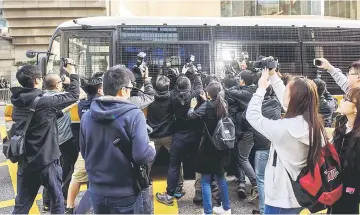  ??  ?? Media surround a prison van holding the seven police officers, who were found guilty on February 14 of assaulting activist Ken Tsang during the 2014 pro-democracy protests, as it arrives at the District Court in Hong Kong. — AFP photo
