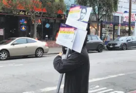  ?? Kate Galbraith / The Chronicle ?? A man campaignin­g for the Juulbacked November ballot measure Propositio­n C holds signs near the Muni stop at Carl and Cole streets in San Francisco.