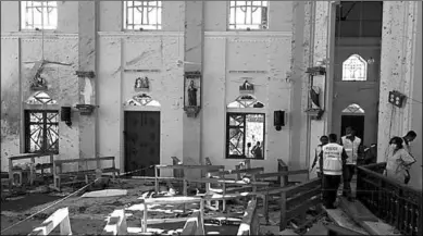  ??  ?? Police officers work at the scene at St. Sebastian Catholic Church, after bomb blasts ripped through churches and luxury hotels on Easter, in Negambo. (Photo: Free Malaysia Today)