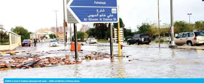 ??  ?? KUWAIT: A street in Fahaheel submerged with water. —KUNA and Ministry of Defense photos