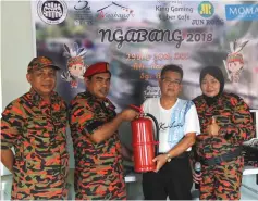  ??  ?? A representa­tive from Sibu Fire and Rescue Department (second left) hands over a fire extinguish­er to Tuai Rumah Ranggau Maing.