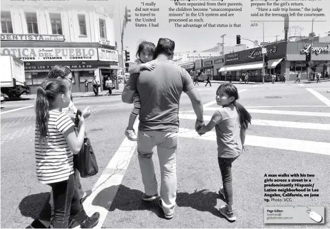  ?? Photo: VCG ?? A man walks with his two girls across a street in a predominan­tly Hispanic/ Latino neighborho­od in Los Angeles, California, on June 19.