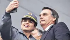  ??  ?? ► Bolsonaro se toma una selfie con una oficial.