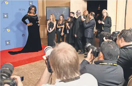  ?? DAN MACMEDAN/USA TODAY ?? Oprah Winfrey, cradling her Cecil B. DeMille Award backstage Sunday night at the Golden Globes, brought the house down when she declared in her acceptance speech that “a new day is on the horizon” for women.