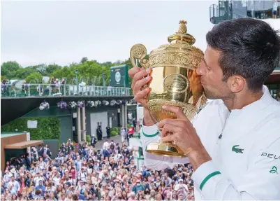  ?? BOB MARTIN/POOL/AFP ?? JUARA LAGI: Ribuan penonton menyaksika­n Novak Djokovic memamerkan trofi juara tunggal putra Wimbledon kemarin dini hari WIB.