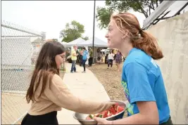  ?? KIMBERLY MORALES — ENTERPRISE-RECORD ?? Madelyn Keen, right walks around the Woofstocks music festival while passing out free watermelon to guests on Saturday, in Chico.