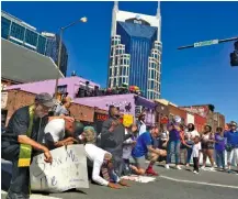  ??  ?? A group of pastors prays in downtown Nashville on Monday after delivering a “moral declaratio­n” to Gov. Bill Haslam’s office demanding economic justice, quality education, health care access, criminal justice reform and equal protection under the law...