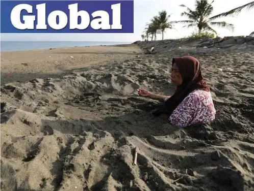  ??  ?? RUMIATI yang mengalami strok ditanam dalam pasir hitam di pantai Syiah Kuala, Banda Aceh, Indonesia. Penduduk tempatan percaya amalan berkenaan dapat mencegah strok dan penyakit darah tinggi. - EPA