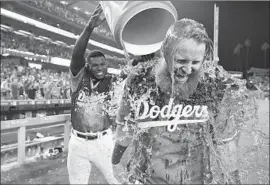  ?? John McCoy Getty Images ?? JUSTIN TURNER IS DRENCHED by Yasiel Puig after the Dodgers third baseman knocked in the winning run on the first pitch after a power outage.