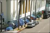  ?? Nelvin C. Cepeda San Diego Union-Tribune ?? TENTS forming an encampment for homeless people line a fence along 8th Avenue in downtown San Diego.