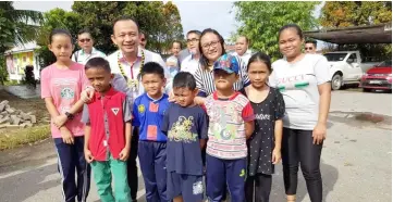  ??  ?? Maszlee poses with pupils of SK Sungai Selad during his visit to the school on Saturday.