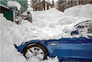  ?? Photos by Salgu Wissmath/The Chronicle ?? Carlos Gonzalez shovels snow off his car in front of his home in South Lake Tahoe on Wednesday. The snowfall inundating California is good for the state’s drought.