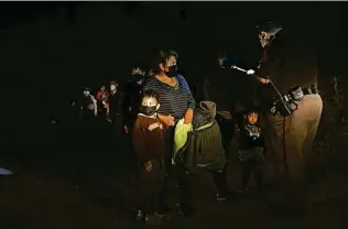  ?? Photos by Jerry Lara / Staff photograph­er ?? A Hidalgo County deputy constable gathers informatio­n Wednesday from migrants who crossed the Rio Grande in an area near Mission known as El Rincon del Diablo, or the Devil’s Corner.