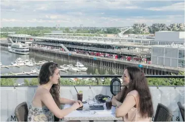  ?? PHOTOS: JUSTIN TANG/ THE GAZETTE ?? Emma Toufali, left, and Jane Jamal spend an afternoon at Terrasse sur l’Auberge, overlookin­g the Old Port.