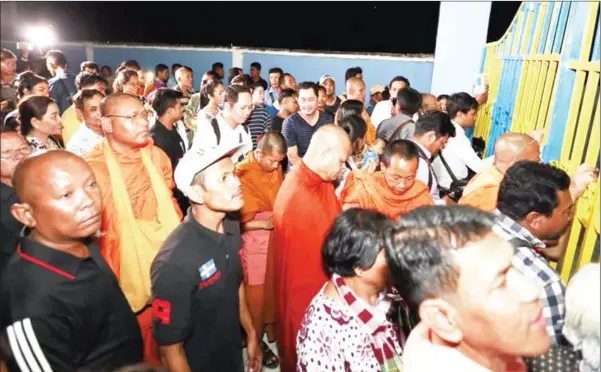  ?? HENG CHIVOAN ?? Supporters, monks and former CNRP members gather in front of Prey Sar prison on Monday night.