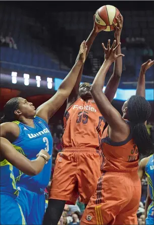  ?? DANA JENSEN/THE DAY ?? Jonquel Jones (35) of the Connecticu­t Sun grabs an offensive rebound over Courtney Paris, left, of the Dallas Wings and Sun teammate Morgan Tuck during Wednesday’s WNBA game at Mohegan Sun Arena. The Sun won 93-87, getting 20 points and 17 rebounds...