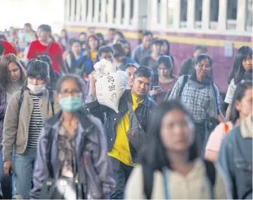  ?? VARUTH HIRUNYATHE­B ?? People arrive at Hua Lamphong railway station to start the new working year.