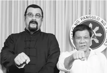  ?? — Reuters photo ?? Duterte and visiting American actor Steven Seagal (left) gesture during a courtesy call by the latter at the Malacanang presidenti­al palace in Manila.