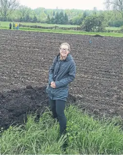  ?? MARKCULLEN.COM ?? After taking possession of their 1,000-sq.-ft. allotment garden on a rainy day last May, Ben’s fiancée Sam gets set to spread compost over the prepared soil.