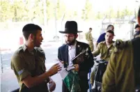  ?? (Tomer Neuberg/Flash 90) ?? AN ULTRA-ORTHODOX man arrives at the Tel Hashomer induction center to enlist for the haredi Netzah Yehuda Battalion yesterday.