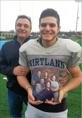  ?? JOHN KAMPF — THE NEWS-HERALD ?? Kirtland senior Dylan Aquila holds a family picture alongside his father Tim. Aquila’s mother, Nancy, died of complicati­ons from leukemia earlier this season.