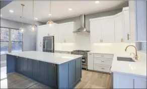  ?? ?? New stainless-steel appliances and white quartz countertop­s accentuate the gourmet eat-in kitchen.