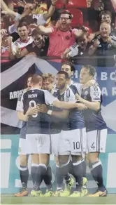  ??  ?? Stuart Armstrong celebrates with teammates, left, after opening the scoring for Scotland from a corner, main picture above. It was his first goal for his country.