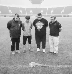  ??  ?? Chinese fans of Ivory Coast internatio­nal and Beijing Enterprise­s club football player Cheick Tiote pay their respects and mark a minute of silence after laying a bouquet of flowers on the field of the National Olympic sport centre stadium in Beijing....