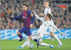  ??  ?? Leo Messi, perseguido por Modric en el Clásico.