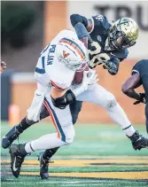  ?? ANDREW DYE/WINSTON-SALEM JOURNAL ?? Virginia tight end Tony Poljan is tackled after a reception by Wake Forest defensive back Zion Keith on Saturday. The Demon Deacons beat the Cavaliers 40-23.