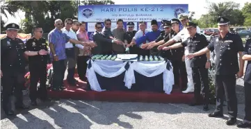  ??  ?? Zulkipli (10th left) leads the 212th Police Day cake-cutting ceremony.