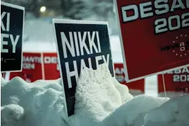  ?? Photograph: Cheney Orr/Reuters ?? Snow-covered campaign signs in Des Moines, Iowa, on 10 January.