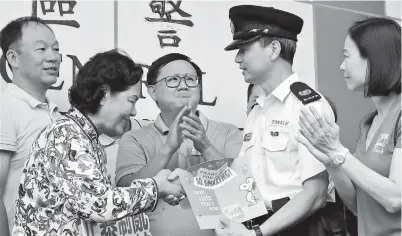  ??  ?? Citizens present a hand-written card as a gift to a police officer at Kwun Tong Police Station in Hong Kong. The Hong Kong police have been praised for showing profession­alism and exercising restraint for two months despite violent protests. — Xinhua