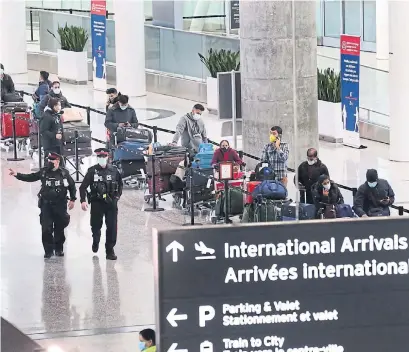  ?? RICHARD LAUTENS TORONTO STAR ?? Passengers wait in line to board busses to quarantine hotels at Pearson airport. Some people have criticized the new rules for being too lenient on travellers, with hotel rooms reportedly costing well below the $2,000-per-person price tag cited by officials.