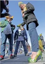  ?? MIKE DE SISTI / MILWAUKEE JOURNAL SENTINEL ?? Shanna Barton of Cincinnati sports Packers high heels while tailgating at Lambeau.