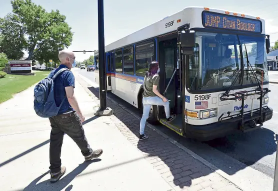  ?? Cliff Grassmick, Daily Camera ?? John Hawthorne-brown and Marisa Parrot board a bus at 55th Street and Arapahoe Avenue this month. Boulder plans to make the intersecti­on a major transit hub that would allow residents and workers to take bus rapid transit and bike or walk to nearby destinatio­ns as part of a plan to redevelop east Boulder.